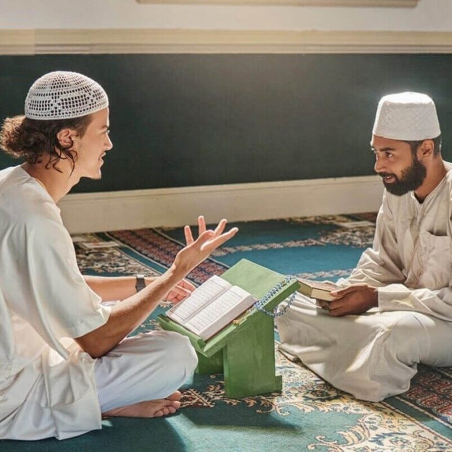 Two Muslim men in conversation in a mosque